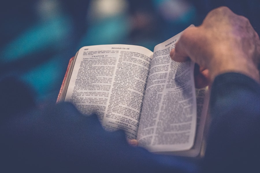 Hands holding an open Bible in cozy lamplight