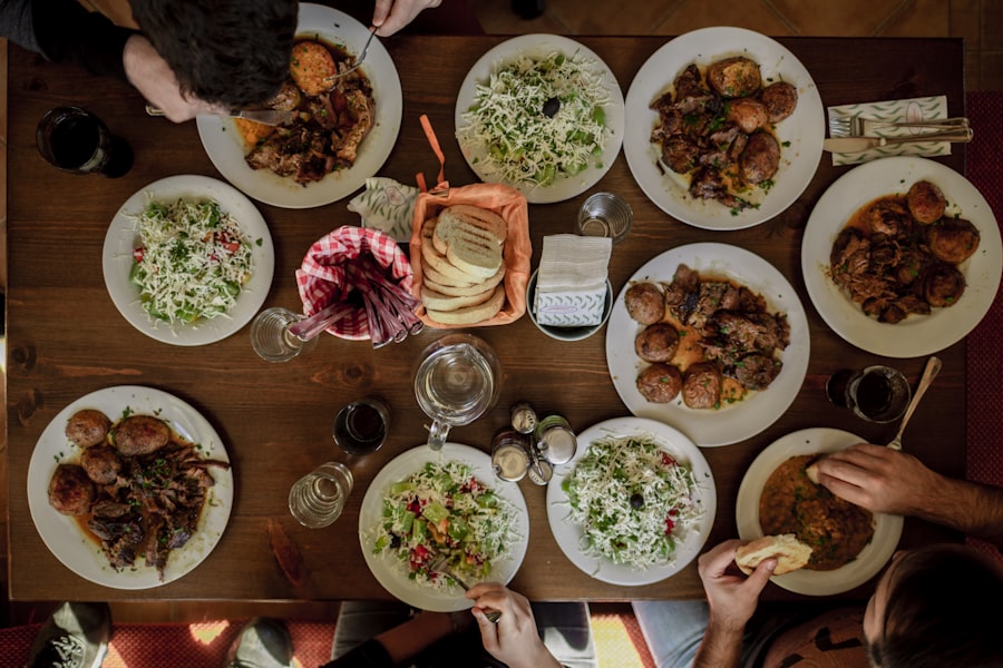 Friends sharing a meal together around a long table, seen from above
